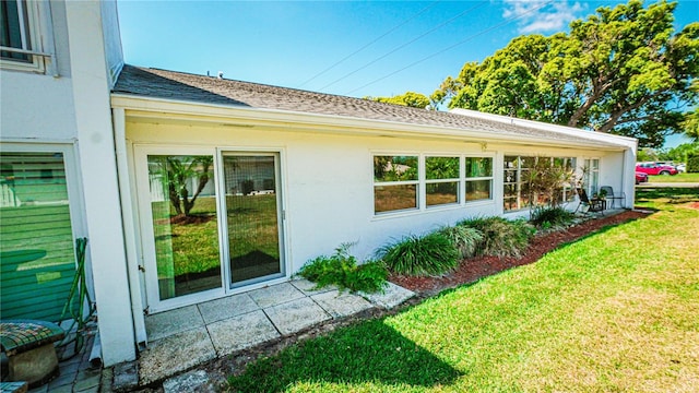 1655 S Highland Ave Unit F126, Clearwater, FL 33756 - view of property exterior featuring a yard, roof with shingles, and stucco siding
