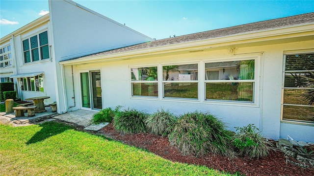 1655 S Highland Ave Unit F126, Clearwater, FL 33756 - back of house with stucco siding and a lawn