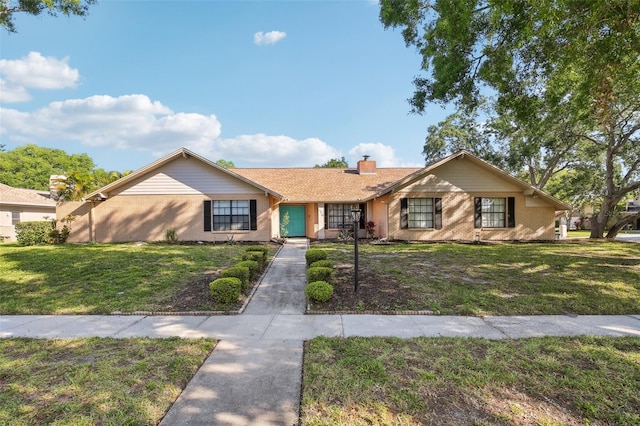 170 Foxfire Ln, Oldsmar, FL 34677 - ranch-style home with a front lawn, brick siding, and a chimney