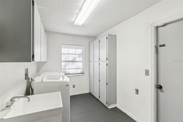 170 Foxfire Ln, Oldsmar, FL 34677 - laundry room featuring a sink, a textured ceiling, separate washer and dryer, cabinet space, and baseboards