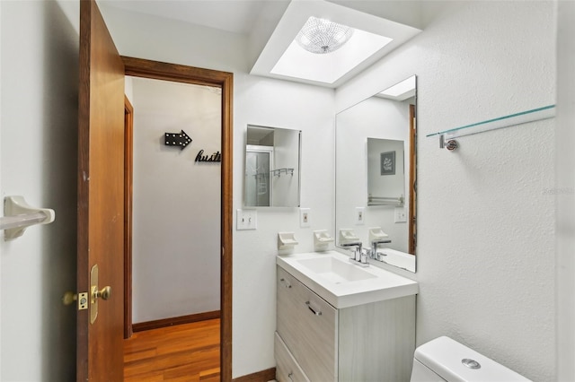 170 Foxfire Ln, Oldsmar, FL 34677 - bathroom featuring toilet, vanity, wood finished floors, and a skylight