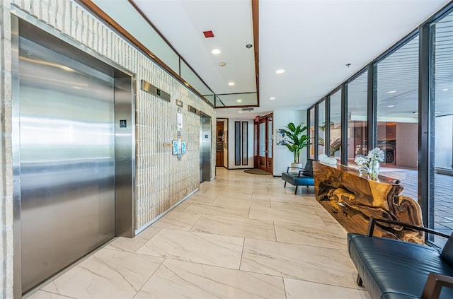 hall featuring recessed lighting, expansive windows, and elevator