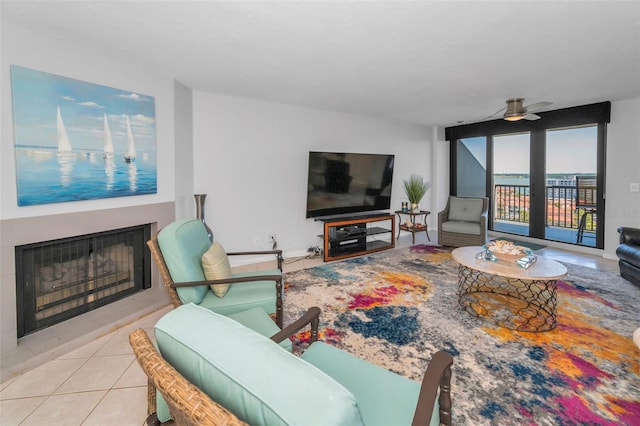 living area featuring a fireplace, a ceiling fan, and tile patterned flooring