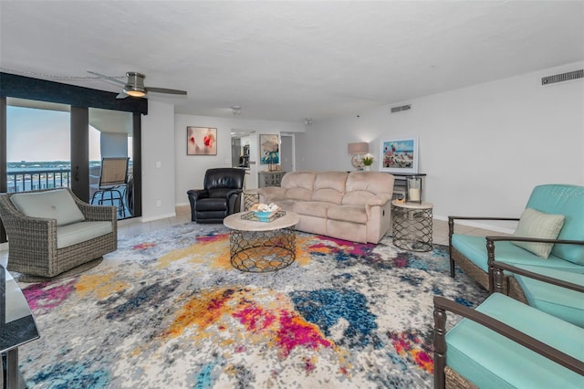 tiled living area featuring visible vents, baseboards, and ceiling fan