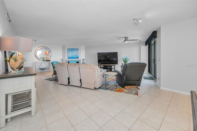 living area with light tile patterned floors and a ceiling fan