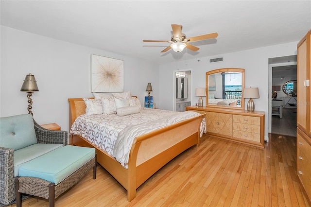 bedroom featuring light wood finished floors, visible vents, and ceiling fan