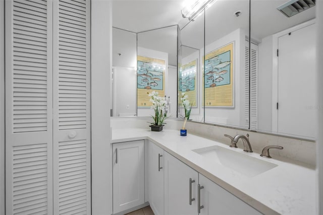 bathroom featuring vanity, a closet, and visible vents