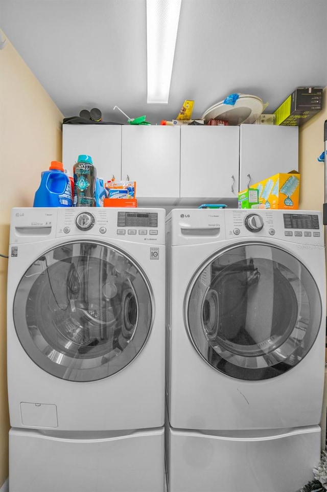 washroom featuring washer and dryer and cabinet space