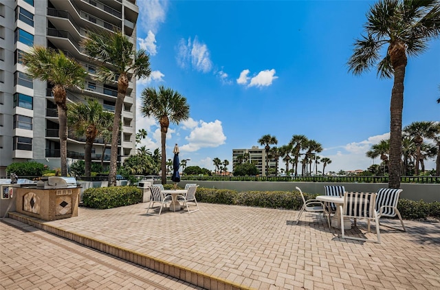 view of patio featuring exterior kitchen, outdoor dining area, and area for grilling