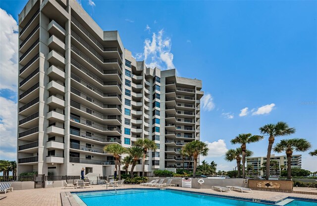 community pool with fence and a patio