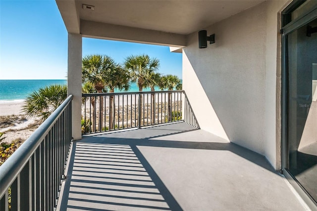 balcony featuring a water view and a view of the beach