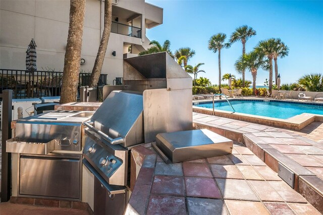 community pool featuring an outdoor kitchen and a patio area