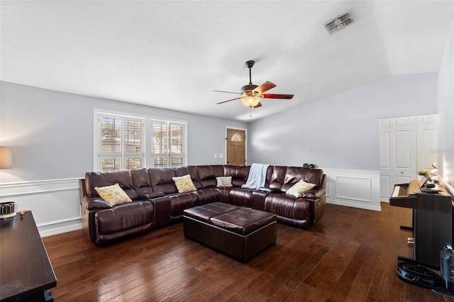 living room with a ceiling fan, vaulted ceiling, hardwood / wood-style floors, a wainscoted wall, and a decorative wall