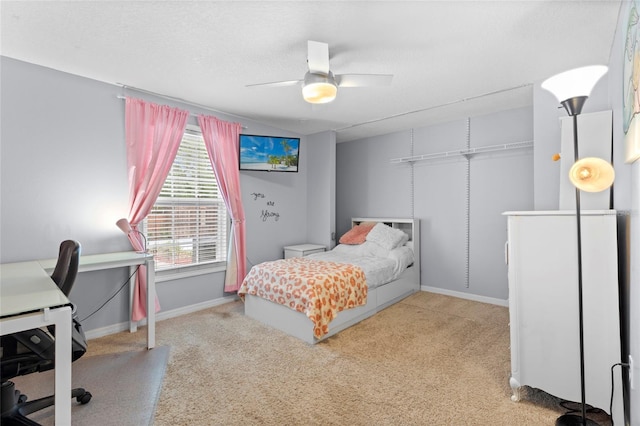 bedroom with carpet floors, a desk, baseboards, and a ceiling fan
