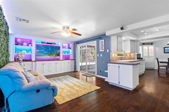 living room featuring a ceiling fan, dark wood finished floors, a textured ceiling, baseboards, and recessed lighting