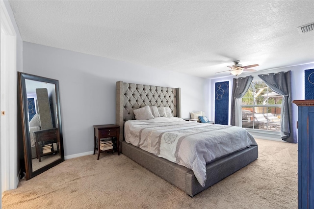 carpeted bedroom featuring a textured ceiling and ceiling fan