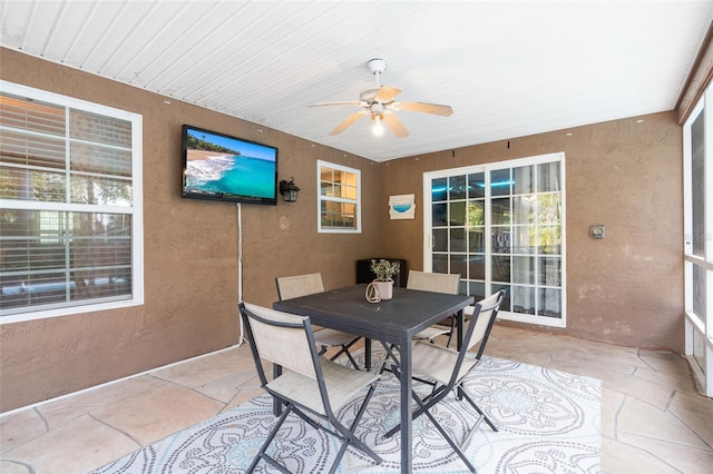 sunroom featuring a ceiling fan and outdoor dining area