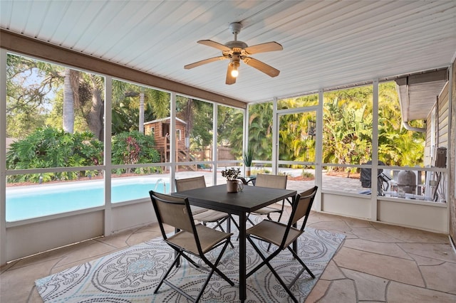sunroom / solarium featuring a ceiling fan and outdoor dining area