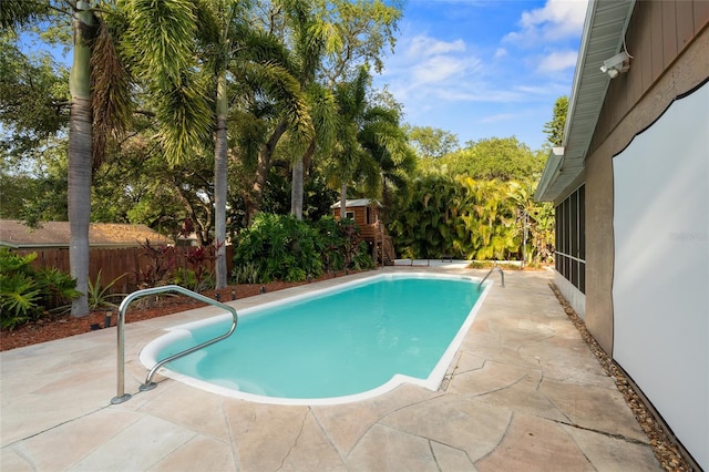 view of swimming pool featuring a patio and fence