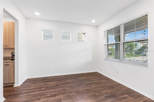 empty room with baseboards, dark wood-style floors, and recessed lighting