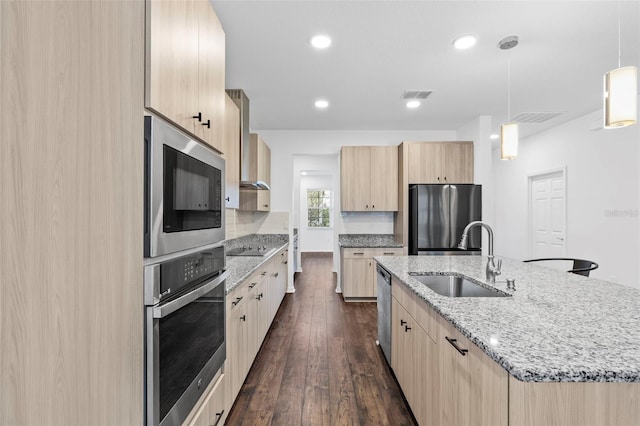 kitchen featuring visible vents, a sink, dark wood-style flooring, appliances with stainless steel finishes, and light brown cabinetry