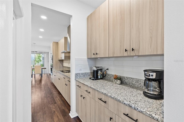 kitchen featuring backsplash, light stone counters, and light brown cabinets