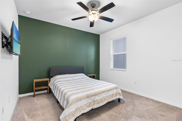 carpeted bedroom with baseboards and a ceiling fan