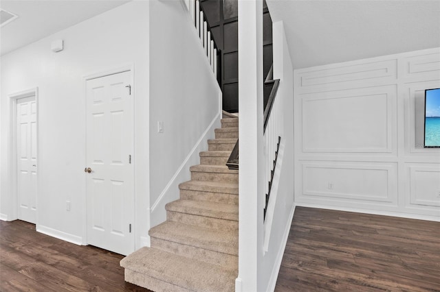 staircase with wood finished floors and baseboards