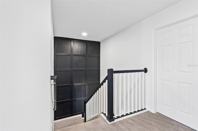 stairs with recessed lighting, a decorative wall, and carpet
