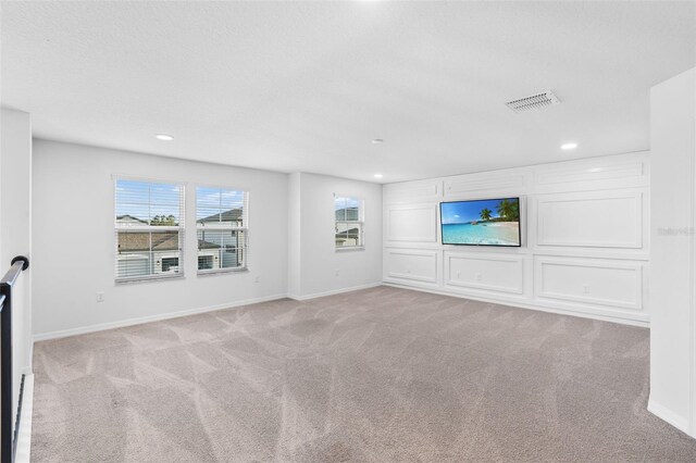 unfurnished living room featuring light carpet, baseboards, and visible vents