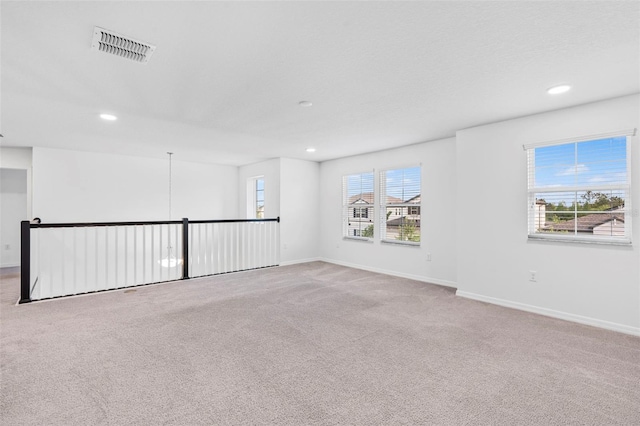 carpeted spare room with recessed lighting, visible vents, and baseboards
