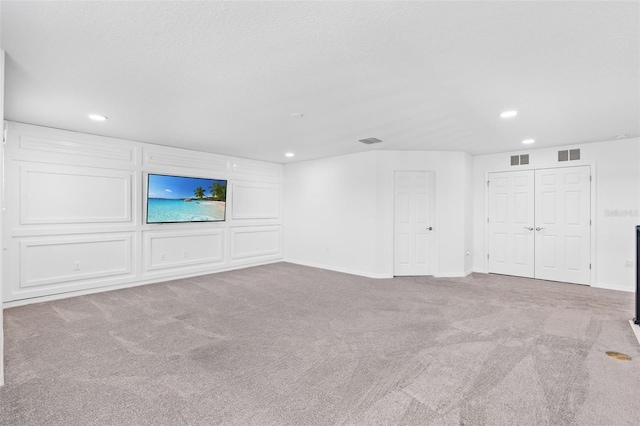 unfurnished living room featuring recessed lighting, visible vents, and carpet floors
