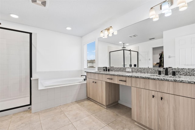 bathroom featuring a stall shower, tile patterned flooring, a bath, visible vents, and a sink