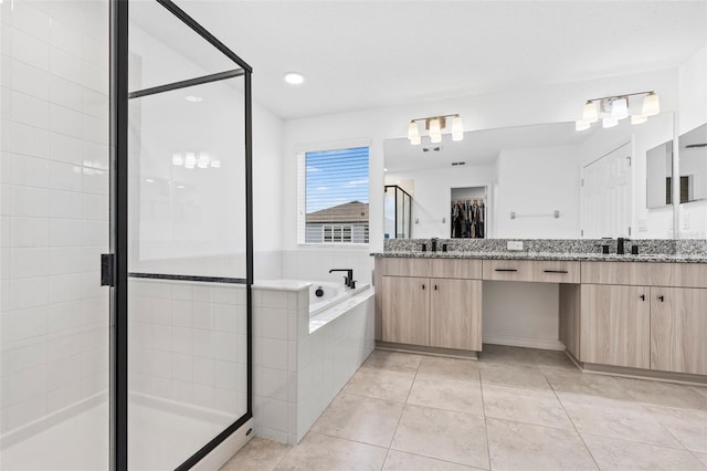 full bathroom featuring a closet, vanity, tile patterned floors, a stall shower, and a garden tub