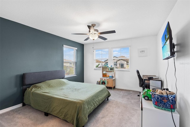 bedroom with light carpet, baseboards, and a ceiling fan
