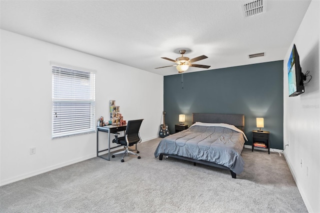 carpeted bedroom with visible vents, baseboards, and a ceiling fan