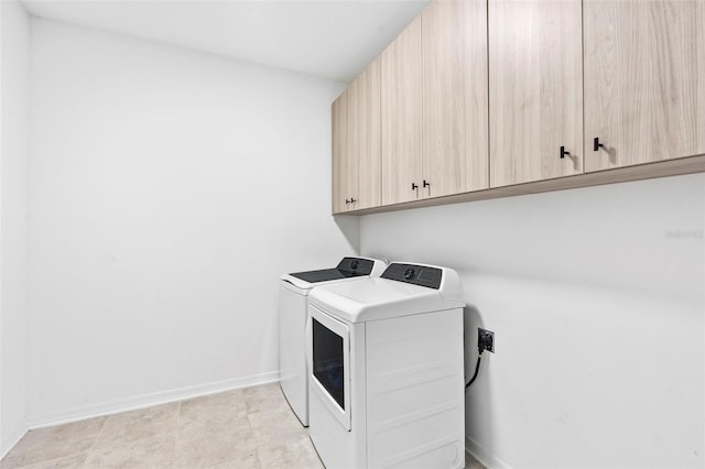 laundry area with washer and clothes dryer, baseboards, and cabinet space
