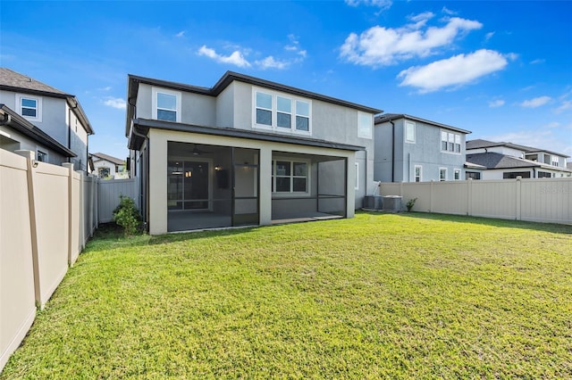 back of property with a yard, a fenced backyard, a sunroom, and stucco siding