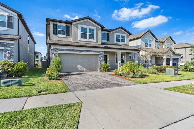 view of front of house featuring an attached garage, driveway, a front yard, and stucco siding