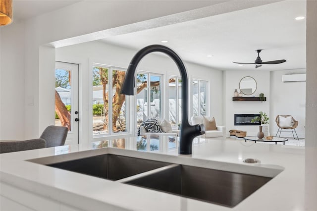 9920 Spoonbill Rd E, Bradenton, FL 34209 - kitchen with a sink, open floor plan, a glass covered fireplace, recessed lighting, and a wall mounted air conditioner