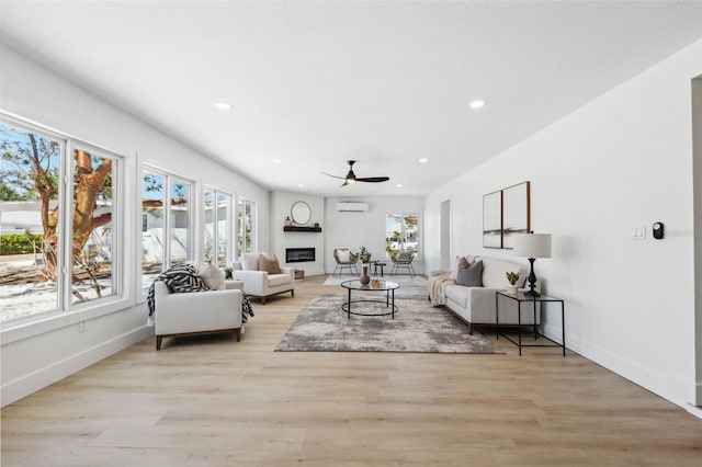 9920 Spoonbill Rd E, Bradenton, FL 34209 - living room with recessed lighting, healthy amount of natural light, a ceiling fan, a wall unit AC, and light wood-style flooring