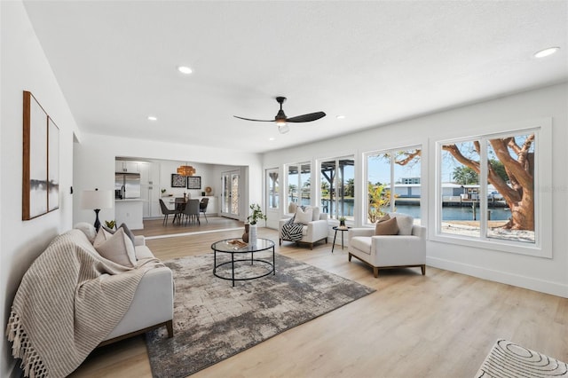 9920 Spoonbill Rd E, Bradenton, FL 34209 - living room with ceiling fan, light wood-style flooring, recessed lighting, a water view, and baseboards