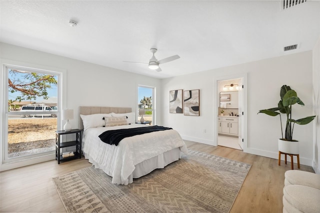 9920 Spoonbill Rd E, Bradenton, FL 34209 - bedroom with light wood finished floors, baseboards, ensuite bath, and a ceiling fan