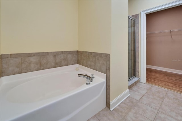6451 Sunset Bay Cir, Apollo Beach, FL 33572 - bathroom with a bath, a spacious closet, a stall shower, baseboards, and tile patterned floors