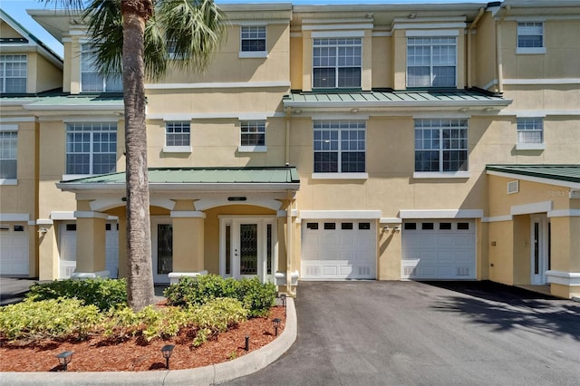 6451 Sunset Bay Cir, Apollo Beach, FL 33572 - view of property featuring stucco siding, driveway, an attached garage, a standing seam roof, and metal roof