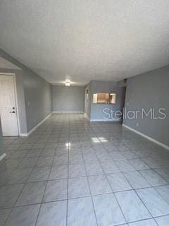 unfurnished living room featuring tile patterned floors and baseboards