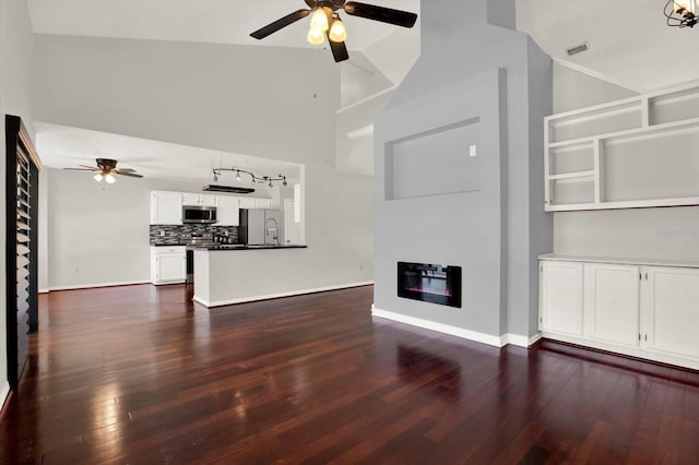 9603 Sunnyoak Dr, Riverview, FL 33569 - unfurnished living room with baseboards, a glass covered fireplace, dark wood-type flooring, and ceiling fan