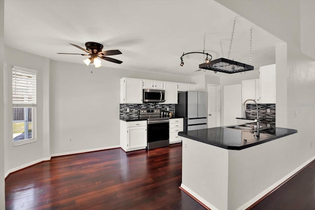 9603 Sunnyoak Dr, Riverview, FL 33569 - kitchen featuring dark countertops, a sink, decorative backsplash, ceiling fan, and appliances with stainless steel finishes