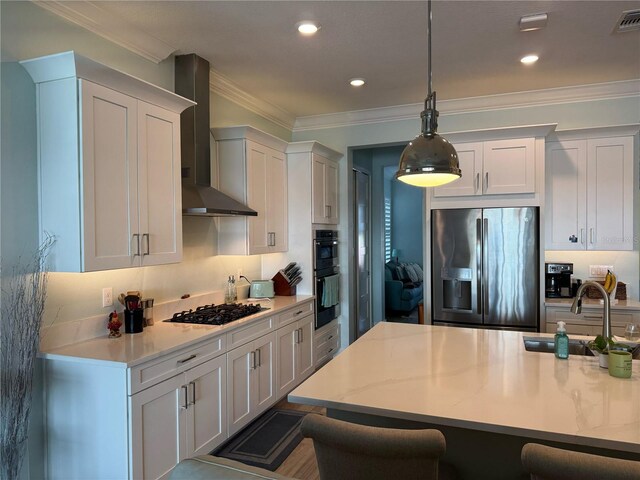 kitchen featuring stainless steel fridge with ice dispenser, wall chimney exhaust hood, gas cooktop, a sink, and a kitchen bar