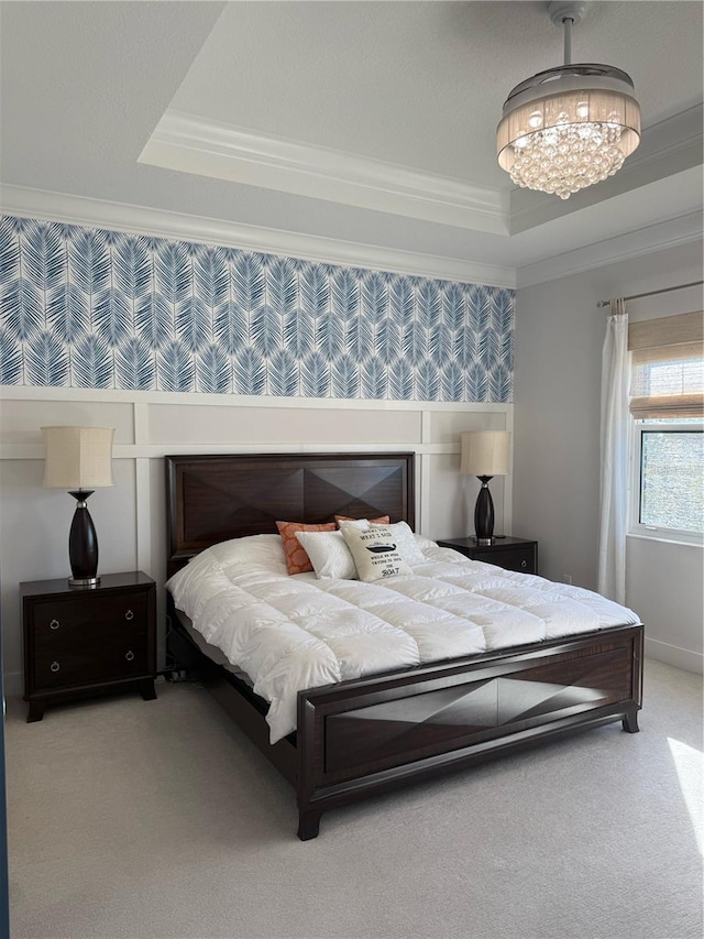 bedroom featuring a tray ceiling, ornamental molding, light colored carpet, and a chandelier
